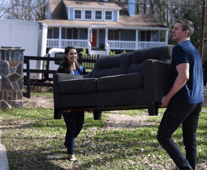 Couple donating a used couch.